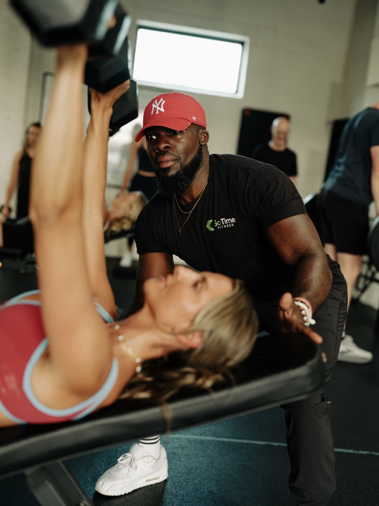 SWC coach spotting a member during a dumbbell press